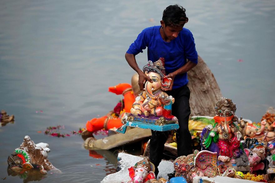 A Man Holds An Idol Of The Hindu God Ganesh, The Deity Of Prosperity, After It Was Immersed In The Waters Of The Sabarmati River