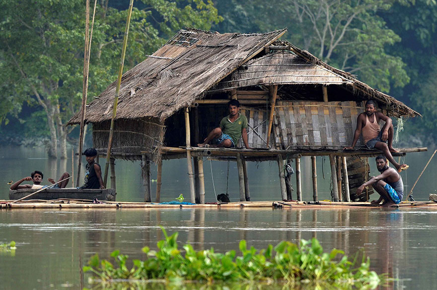 Villagers Take Shelter In A Partially Submerged House Following Floods At Baghmari Village In Nagaon District, In The Northeastern State Of Assam, India