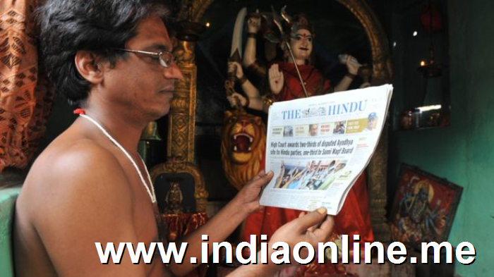 Indian Hindu priest Krishnama Charyulu reads a newspaper with the high court verdict of disputed Ayodhya case inside the temple in Hyderabad on October 1, 2010.