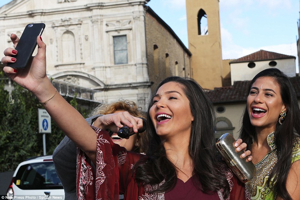 Three guests at the wedding snap a selfie on their mobile phone. Around 500 people were expected to have attended the nuptials